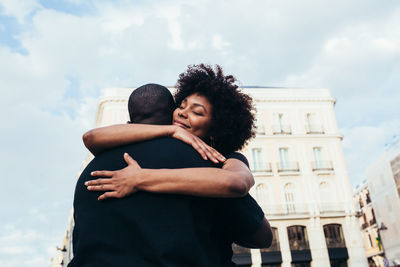 Happy african american couple hugging on the street in a summer day