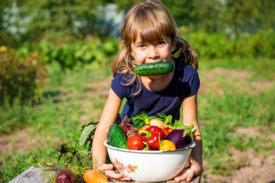 Portrait of girl with fresh bowl of vegetables