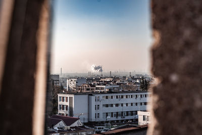 High angle view of buildings against sky seen through railing