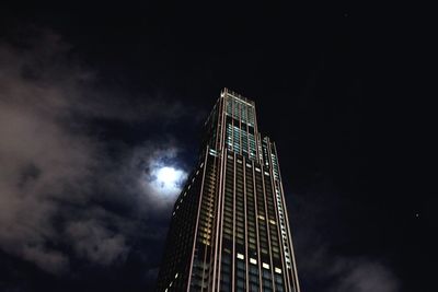 Low angle view of modern building against cloudy sky