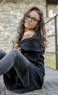 Portrait of woman sitting on footbridge