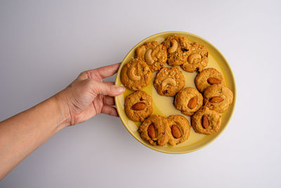 Midsection of person holding cookies against white background