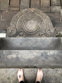 Low section of woman standing on cobblestone