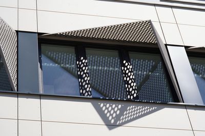 Low angle view of window at building with patterns of shadow