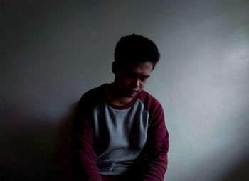 Young man looking away against white background