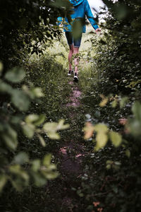 Low section of woman running on footpath