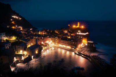 High angle view of city lit up at night