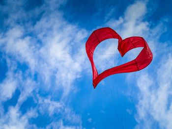 Low angle view of heart shape kite flying against sky