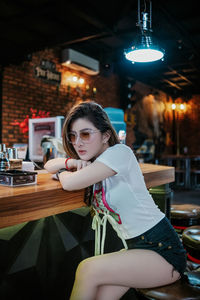 Portrait of young woman sitting on table