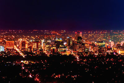 Illuminated cityscape against sky at night