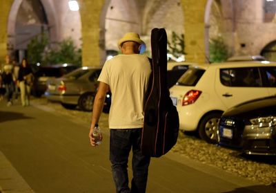 Rear view of man walking on street in city