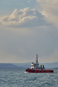 Ship sailing on sea against sky during sunset