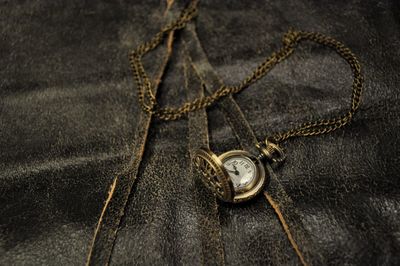 High angle view of pocket watch on textile