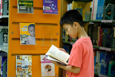 Side view of a boy holding book