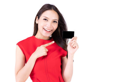 Portrait of a smiling young woman standing against white background