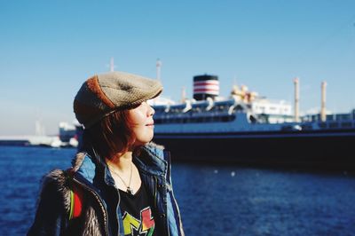 Woman wearing hat against sea against sky