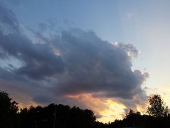 Silhouette of trees against cloudy sky