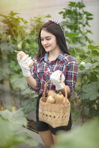 Young woman holding a plant