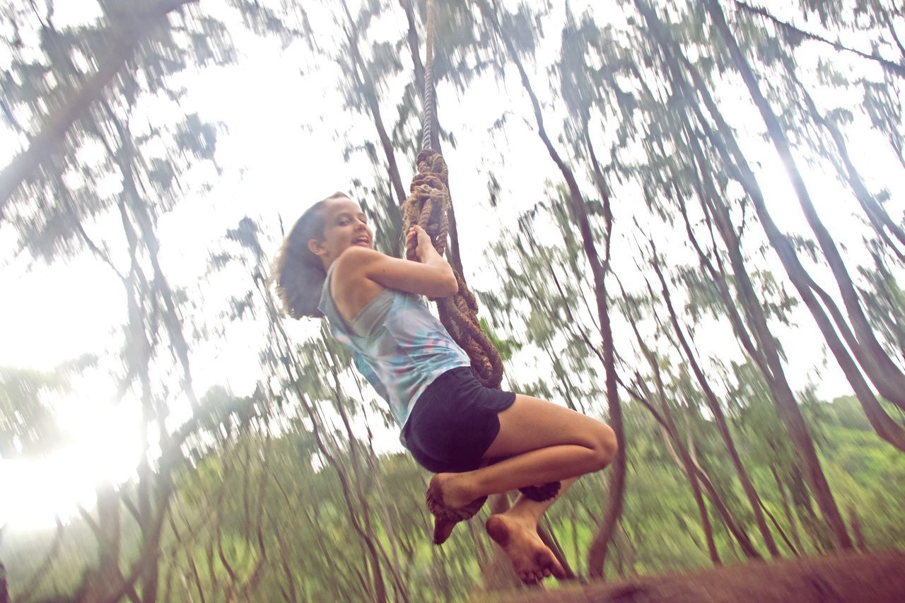 LOW ANGLE VIEW OF MAN ON TREE