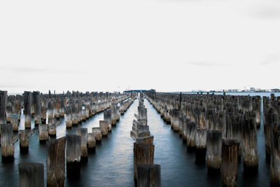 Panoramic view of wooden posts in sea against clear sky