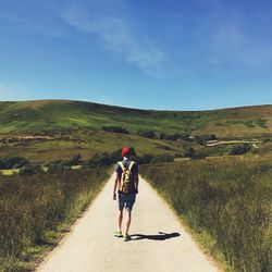 Rear view of woman on road against sky