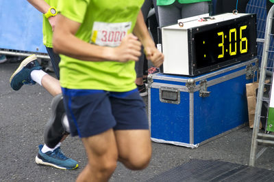 Low section of men running on road in marathon