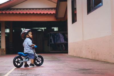 Side view of woman riding bicycle on building