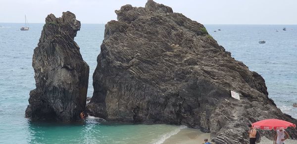 Rock formation on beach against sky