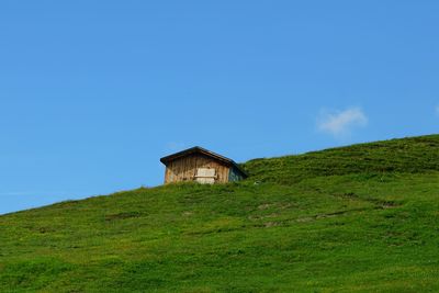 House on field against blue sky