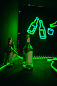 Close-up of wine glass bottle on table at night