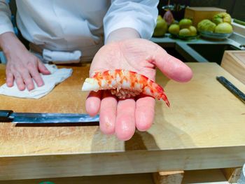 Midsection of person preparing food on cutting board