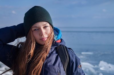 Portrait of young woman against sea