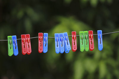 Close-up of clothespins hanging on rope