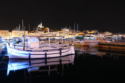 Boats moored in harbor at night