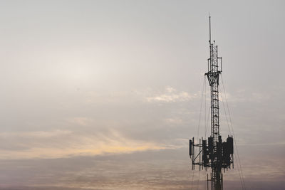 Low angle view of communications tower against sky during sunset