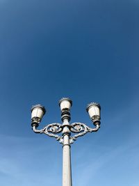 Low angle view of street light against blue sky