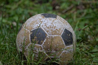 Close-up of old soccer ball on field