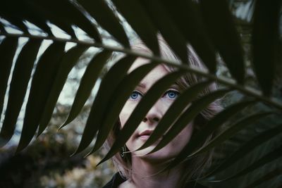 Close-up portrait of woman seen through leaves