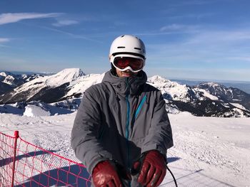 Man skiing on snow covered mountain against sky