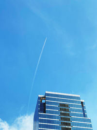 Low angle view of modern building against blue sky