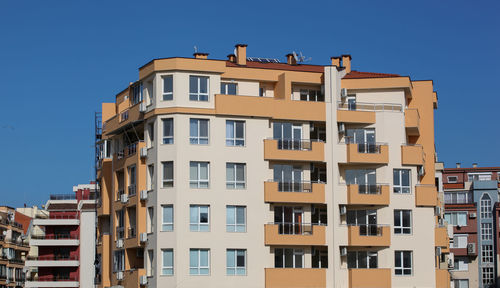 Low angle view of residential buildings against clear blue sky