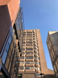 Low angle view of modern buildings against clear blue sky