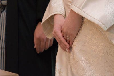 Midsection of couple holding hands