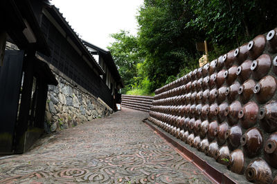 Walkway amidst trees against sky