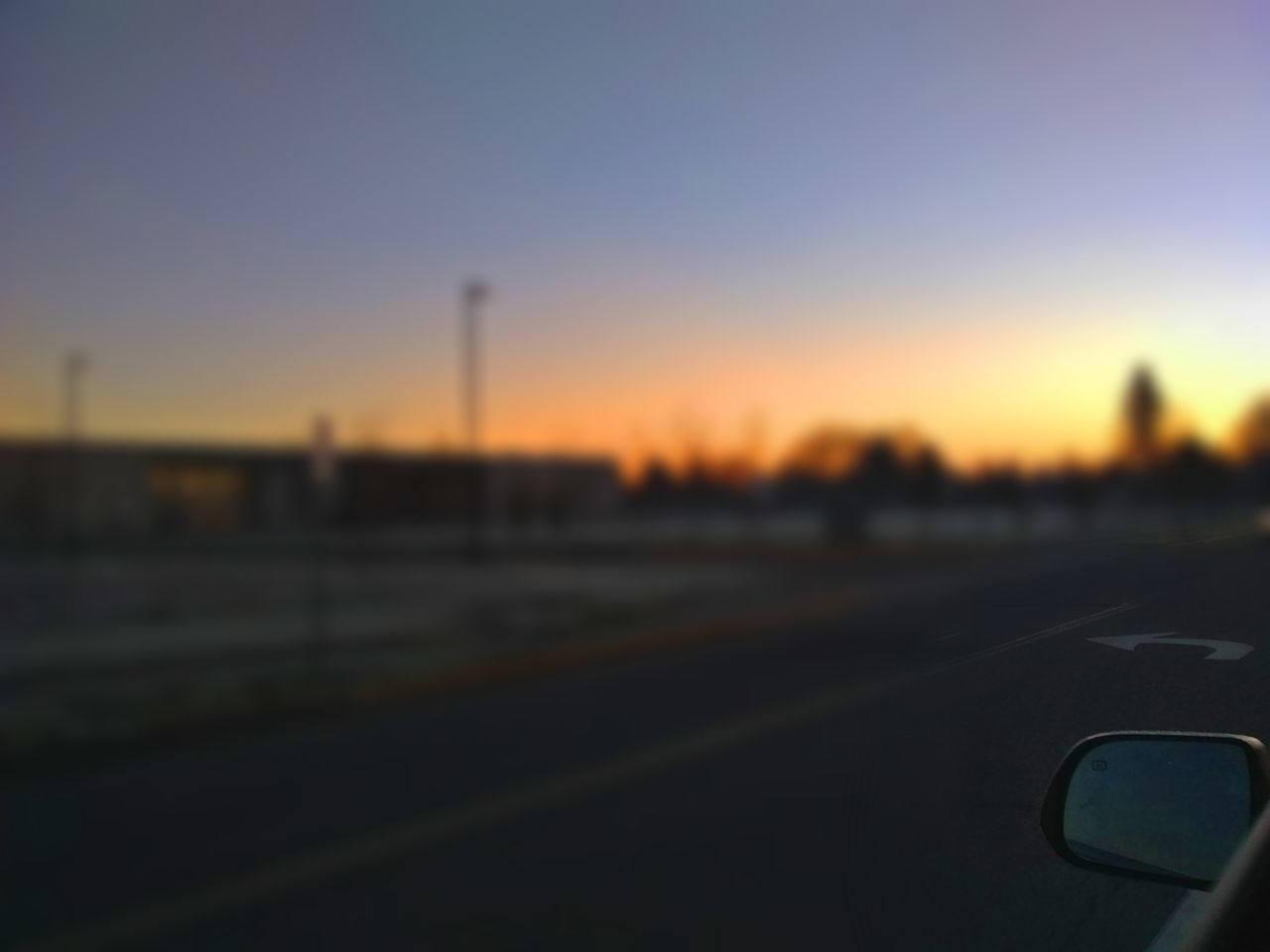 CLOSE-UP OF CAR WINDSHIELD AGAINST CLEAR SKY DURING SUNSET