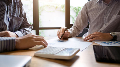 Midsection of man and woman sitting on table