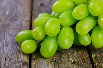 Close-up of green grapes on wooden table