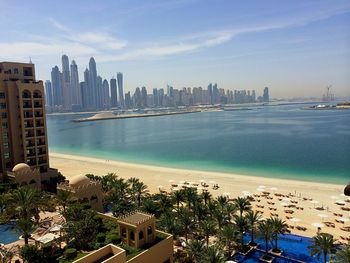 Scenic view of sea by buildings against sky