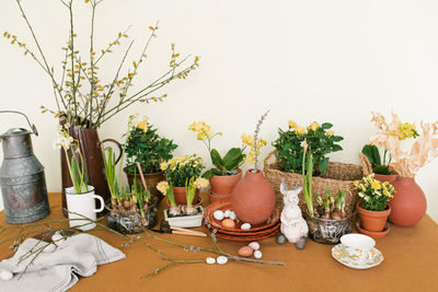 Easter holiday decor. daffodils and hyacinths in a pot, eggs and a rabbit figurine and branches