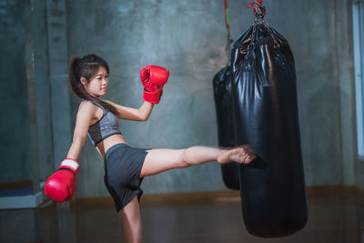 Female boxer kicking punching bag